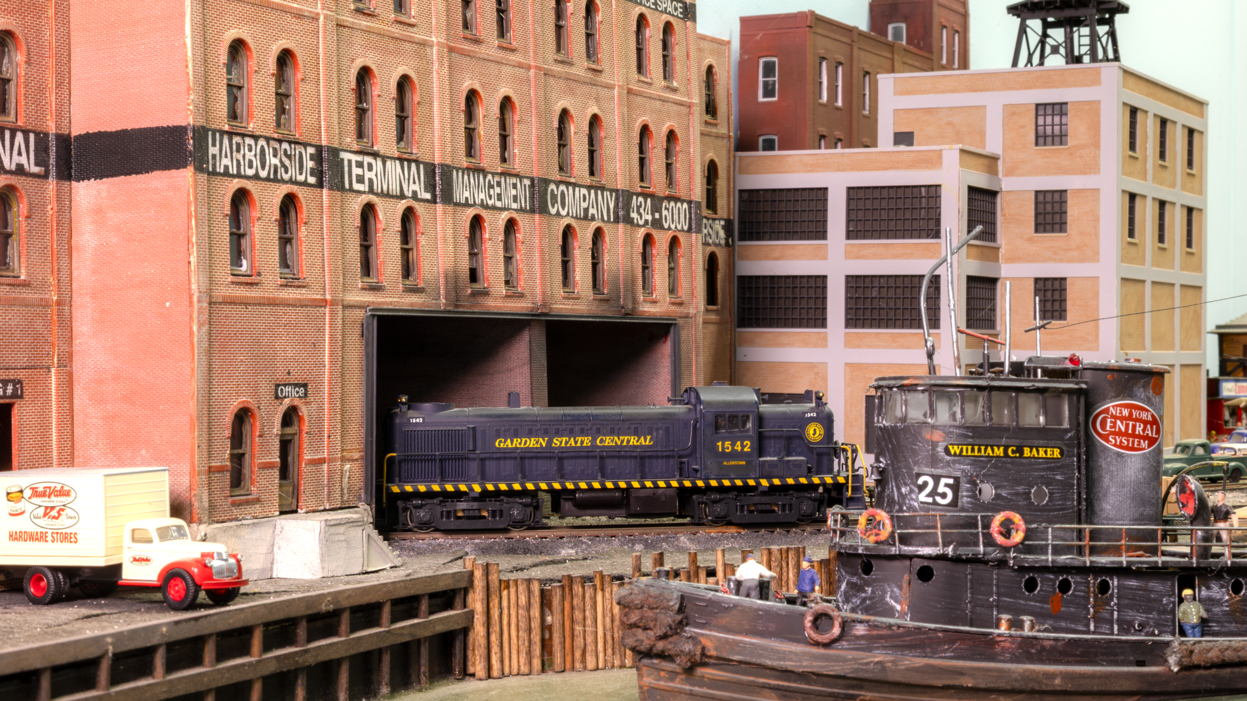 Tug boats and large ocean-going ships mingle with trains in Jersey City. 